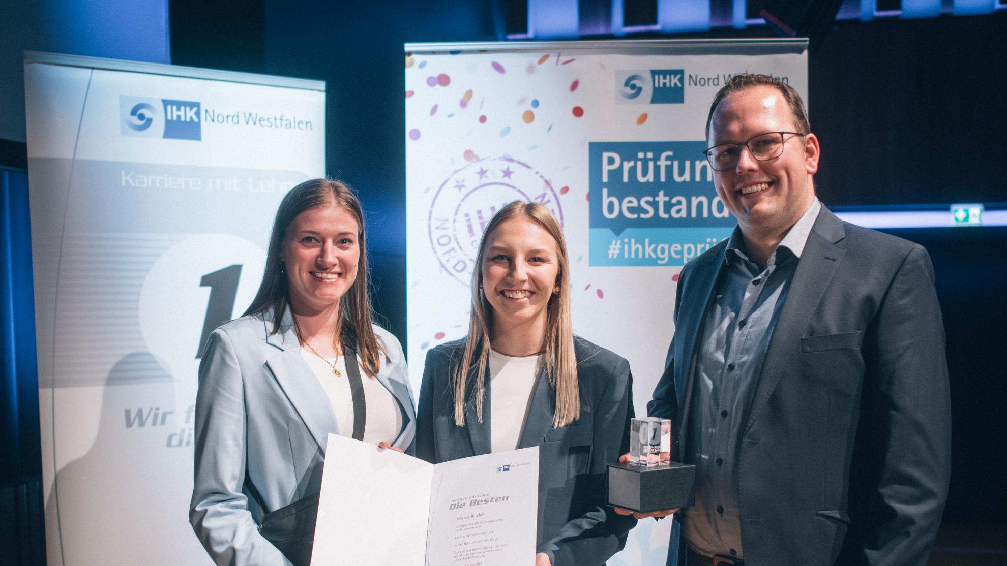 Ausbildungsleiterin Nadine Hils und Yann Schwietering (Bereichsleiter Zentrale Dienste, Caritasverband Ahaus-Vreden) beglückwünschen Johanna Büscher (M.).