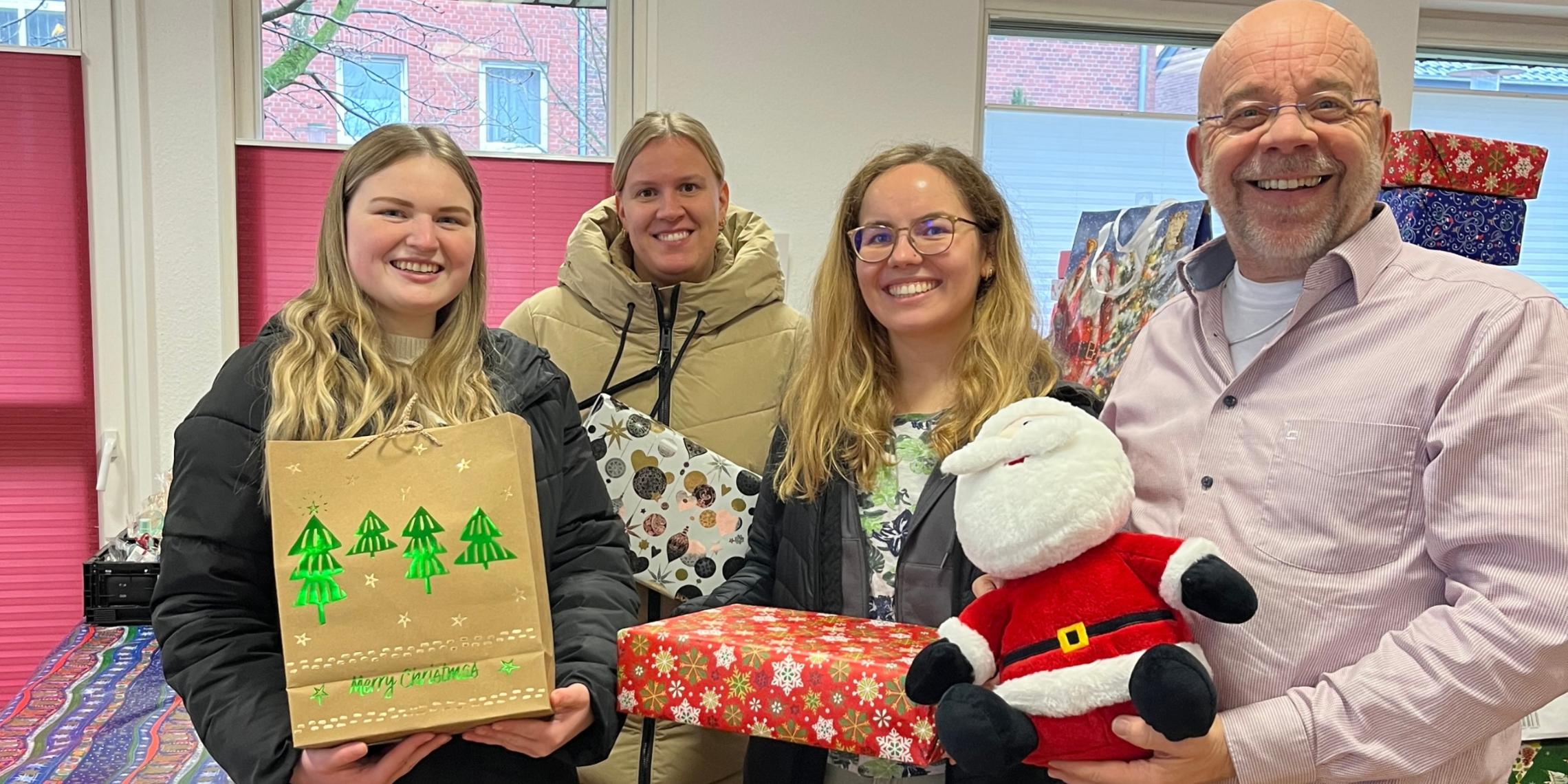 Johannes Lügering (r.) von der Ahauser Tafel und die Auszubildenden Alessia Bone, Helena Reckert und Isabell Leesker bei der Übergabe der Weihnachtspäckchen.