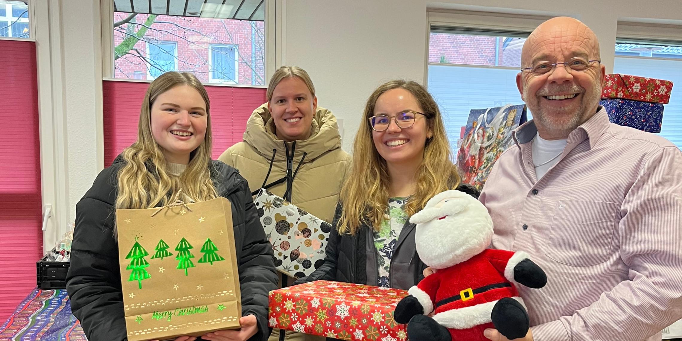 Johannes Lügering (r.) von der Ahauser Tafel und die Auszubildenden Alessia Bone, Helena Reckert und Isabell Leesker bei der Übergabe der Weihnachtspäckchen.