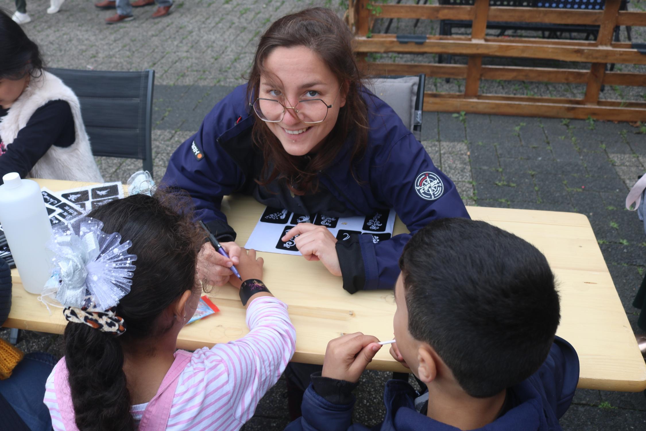 Lara Jansen von youngcaritas malte Kindern Tattoos auf Arme und Hände.